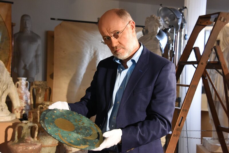 Harald Lesch mit einer Nachbildung der Nebra-Scheibe, die als früher Himmelskalender gilt. – Bild: ZDF/​Peter Prestel