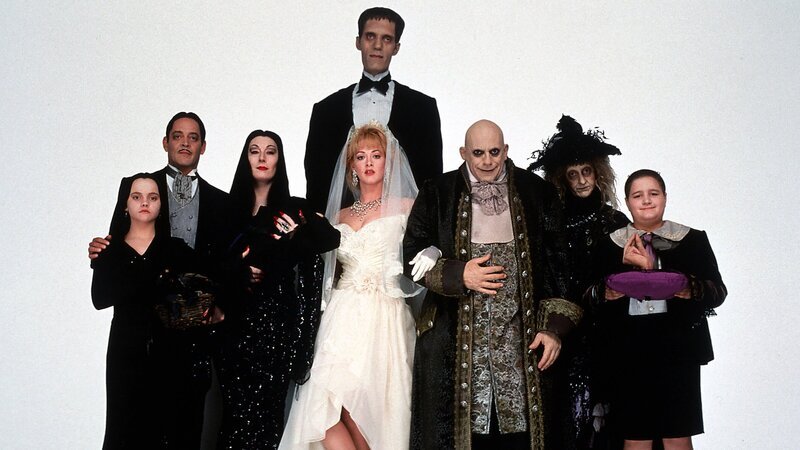 Die düstere Familie Addams feiert die Liebe zwischen Onkel Fester (Christopher Lloyd, 3.v.r.) und Debbie (Joan Cusack, M. vorne). Wednesday (Christina Ricci, l.), das Ehepaar Morticia (Anjelica Huston, 3.v.l.) und Gomez Addams (Raúl Juliá, 2.v.l.), Lurch (Carel Struycken, M. hinten), Großmutter (Judith Malina, 2.v.r.) und Pugsley (Jimmy Workman, l.) trauen der geheimnisvollen Debbie jedoch nicht. – Bild: ZDF und Melinda Sue Gordon Die düstere Familie Addams feiert die Liebe zwischen Onkel Fester (Christopher Lloyd, 3.v.r.) und Debbie (Joan Cusack, M. vorne). Wednesday (Christina Ricci, l.), das Ehepaar Morticia (Anjelica Huston, 3.v.l.) und Gomez Addams (Raúl Juliá, 2.v.l.), Lurch (Carel Struycken, M. hinten), Großmutter (Judith Malina, 2.v.r.) und Pugsley (Jimmy Workman, l.) trauen der geheimnisvollen Debbie jedoch nicht. – Bild: ZDF und Melinda Sue Gordon