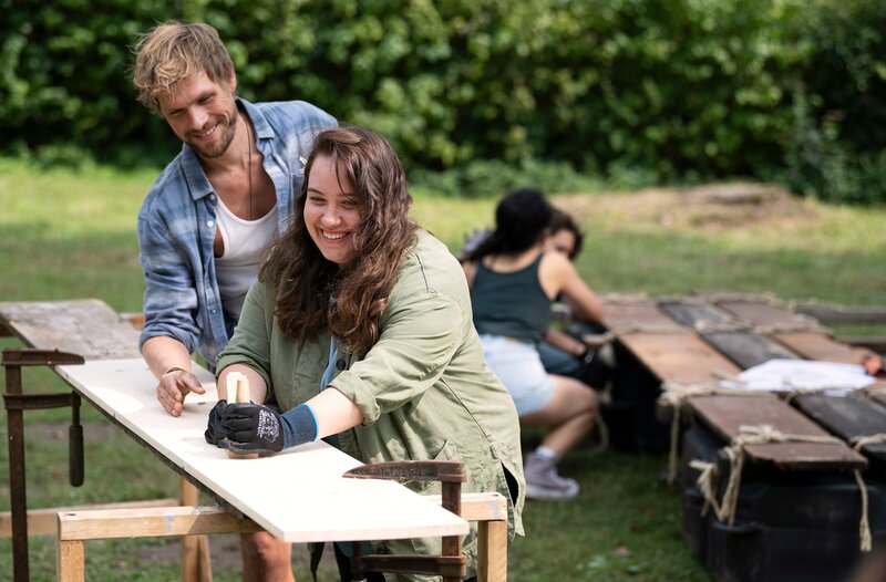 Kiara Holm (Dilara Aylin Ziem, 2.v.l.), und Dennis Rutschinski (Remo Schulze, l.) bauen nicht nur zusammen ein Floß. Sie treffen sich auch heimlich. – Bild: ARD/​Laurent Trümper