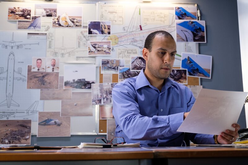 Der ägyptische Ermittler (gespielt von Nabeel El Khafif) sieht sich ein Foto vom Absturz des MetroJet-Flugs 9268 an. – Bild: The National Geographic Channel