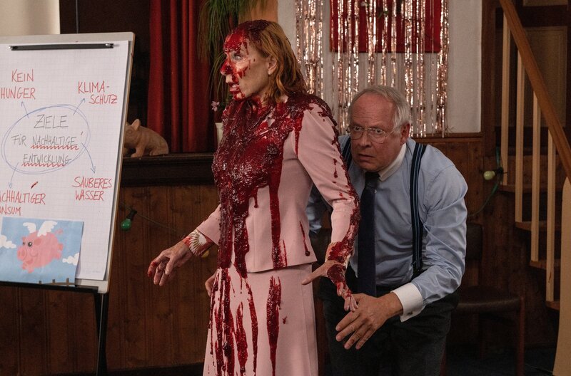 Gerald Bundschuh (Axel Milberg) hat sich geschickt hinter seiner Frau Gundula (Andrea Sawatzki) versteckt, um nicht mit Schweineblut übergossen zu werden. – Bild: ZDF und Britta Krehl