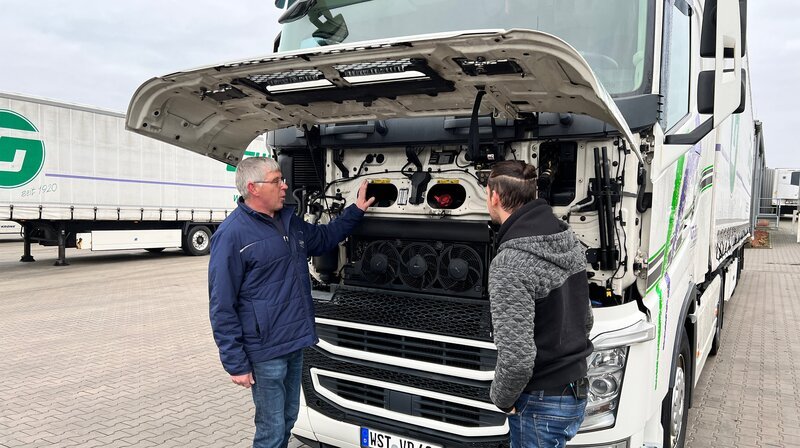 Einweisung für den neuen Fahrer: Max (r.) hat gerade erst sein Vorstellungsgespräch gehabt und muss schon auf die erste Fahrt nach Ulm. Vorher gibt es eine Einweisung in den Lkw vom Fuhrparkleiter der Spedition Grüßing aus Westerstede. – Bild: NDR/​LEMON8/​Thorsten Schöntaube /​ NDR Presse und Information
