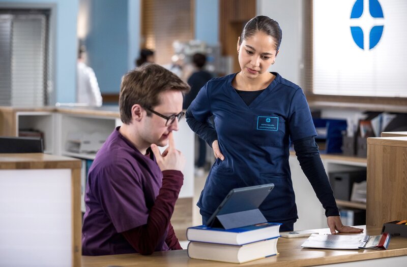 Olli (Arne Kertész) rätselt mit Sofia (Olivia Papoli-Barawati) über ein CT-Bild seines Patienten. Was befindet sich nur in der Lunge des jungen Mannes? – Bild: ARD/​Michael Kremer