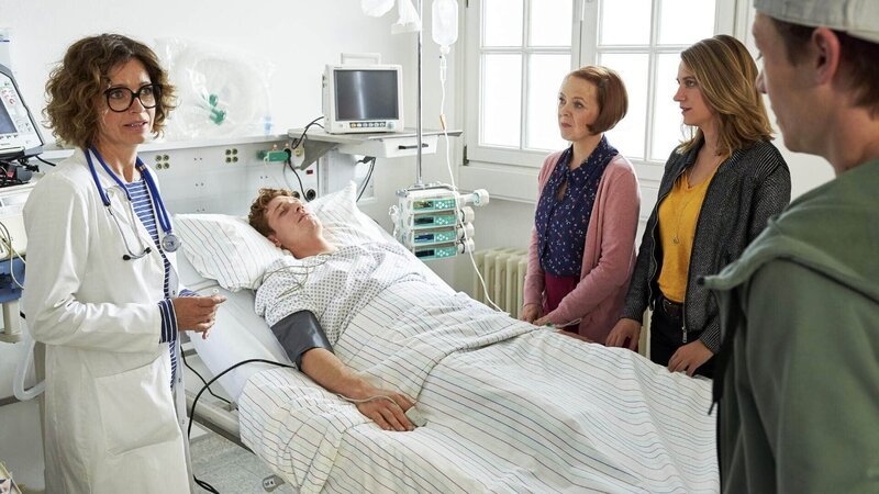 Oberärztin Frau Haase (Madeleine Niesche, l.) klärt Haushälterin Maria (Susi Banzhaf, 3.v.r.), Polizistin Eva (Bettina Burchard, 2.v.r.) und Kevin (Vincent Krüger, r.) über Maiks (Daniel Donskoy) Koma-Zustand auf. – Bild: TVNOW /​ Guido Engels