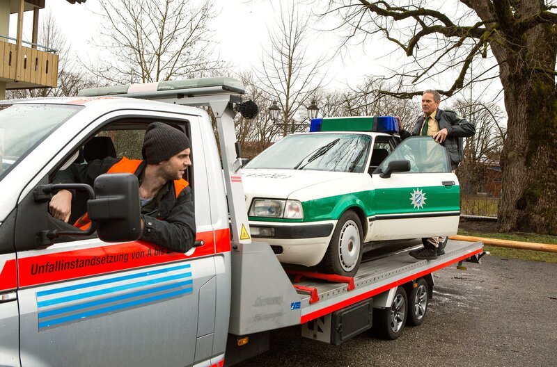 Der Streifenwagen steht im Halteverbot – Gabriel Haas (Michael Wächter, l.) will ihn abschleppen. Hubert (Christian Tramitz, r.) versucht das zu verhindern. – Bild: ARD/​Kai Neunert