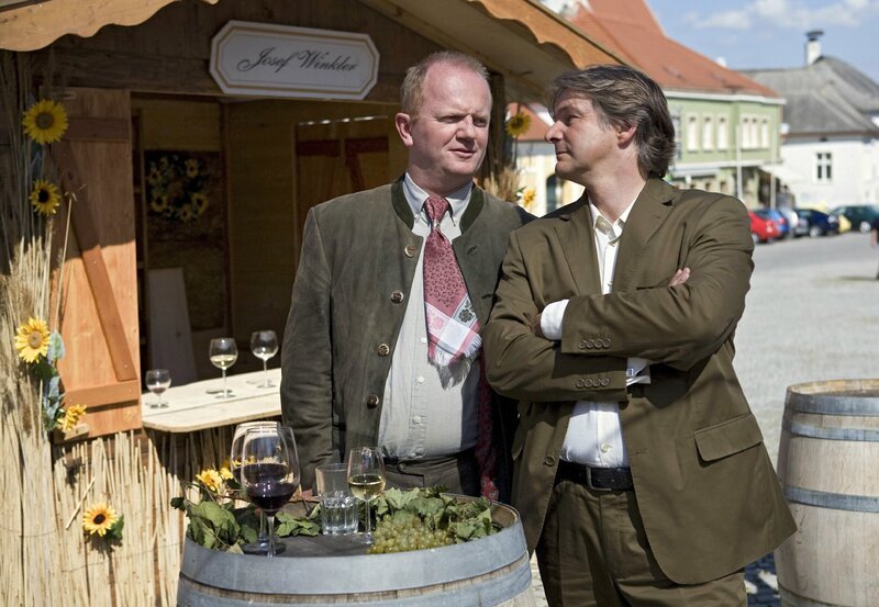Weinverkostung in Rust: Andreas Koblenz (Max Herbrechter, r.) plaudert mit Josef Winkler (Edmund Jäger, l.). – Bild: BR/​HR/​ORF/​Georg Bodenstein