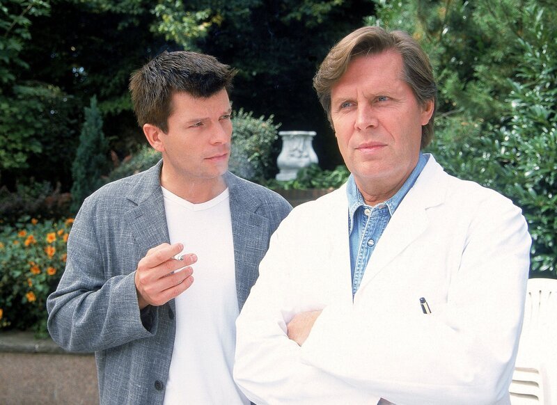 Sebastian von Kleritz (Nikolaus Gröbe) erzählt Dr. Stefan Frank (Sigmar Solbach), dass seine Mutter will, dass er eine Verlags-Mitarbeiterin heiratet und nicht weiss, dass Sebastian homosexuell ist. – Bild: RTLplus