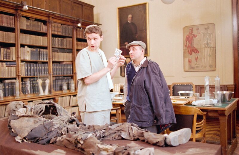 Richard Fellner der behauptet der rechtmäßige Erbe von Schloss Esslan zu sein, übergibt seinem Freund Alfons Beifuss einen Finger der toten Gräfin für einen Gentest (v.li.: Martin Puntigam, Christoph Fälbl). – Bild: ORF III