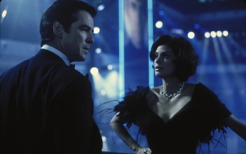 James Bond (Pierce Brosnan) versucht über seine frühere Liebe Paris (Teri Hatcher) an deren Mann, den Medienmogul Elliot Carver, heranzukommen. – Bild: RTL Nederland