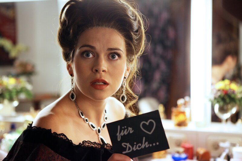 Die Soubrette Renate Wasmuth (Sieglinde Feldhofer) ist entsetzt zu erfahren, dass der Mordanschlag mit der vergifteten Praline ihr galt. – Bild: ORF 1