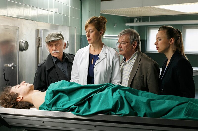 Der ermordete Ex-Junkie Julius (Jascha Baum, liegend) war clean. Dr. Rosalind Schmidt (Helene Grass, 2.v.l.) erläutert Edwin Bremer (Tilo Prückner, l.), Günter Hoffmann (Wolfgang Winkler, 2.v.r.) und Vicky Adam (Katja Danowski, r.) die Laborergebnisse. – Bild: ARD/​Kai Schulz