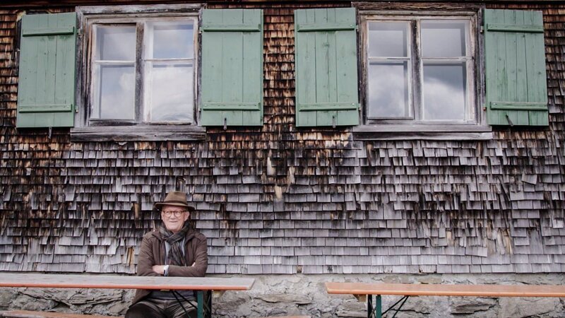 Ein Porträt von Franz Fetz, ehemaliger Inhaber des Hotel Hirschen, auf einer Bank. – Bild: ServusTV /​ Degn Film