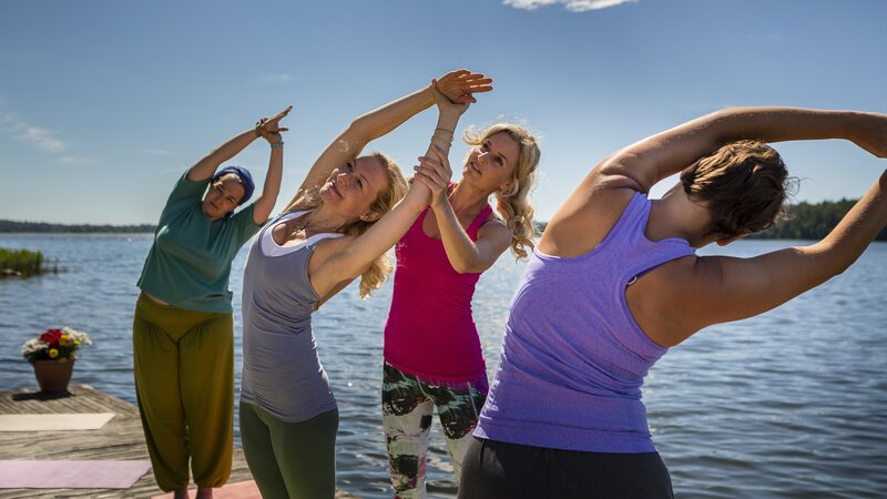 Esther Carlson (Franziska Schlattner, 2. v.r.) unterrichtet ihre Schülerinnen Rosi (Barbara Bauer, l.), Mia (Tanja Seehofer, 2. v.l.) und Hanna (Naida Raginuva, r.) in einer Yogastunde am Steg. – Bild: ZDF/​Arvid Uhlig