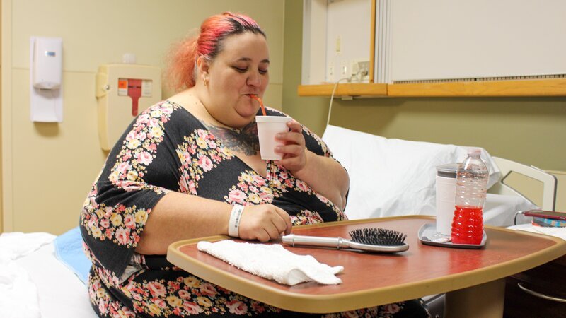 Angie sits in hospital bed at bedside table – Bild: Discovery Communications, LLC