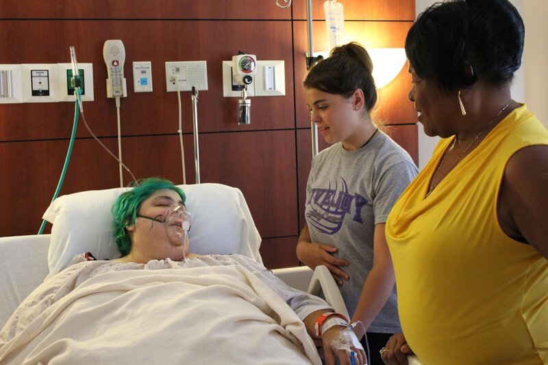 ep 2, Paula sleeping on the hospital bed with her family and friends by her side. – Bild: Discovery Communications /​ Discovery Networks