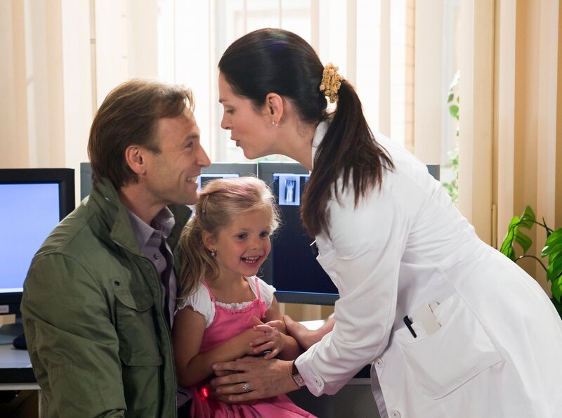 Sophie will unbedingt ihre Mama Elena Eichhorn (Cheryl Shepard) aus der Klinik abholen. Doch Elena hat noch einige Patienten zu versorgen und bittet Martin Stein (Bernhard Bettermann) und ihre Tochter, noch ein bisschen zu warten. – Bild: MDR/​Peter Krajewsky