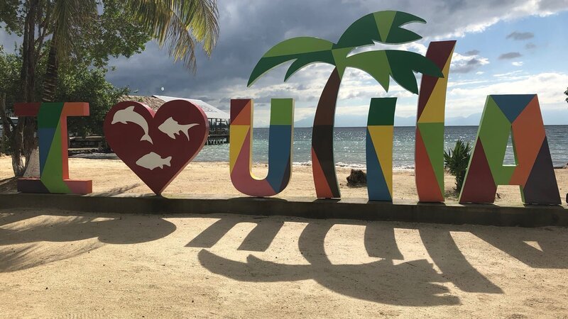 The „i love Utila“ sign on Chepes Beach, in Utila, Honduras. As seen on HGTV’s Caribben Life – Bild: HGTV /​ Scripps (Focus) HCBLF1301_308321 /​ Scripps Networks, LLC.