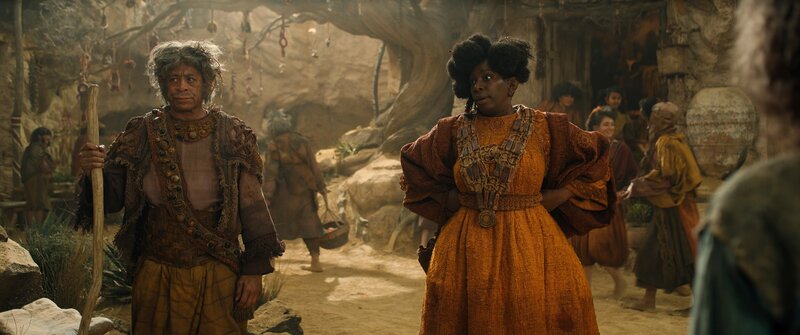 Gundabale (Tanya Moodie, r.), die Anführerin der Starren, und ihr Stammesgenosse Marmadas (Peter Landi, l.) sind nicht gerade begeistert, als die Harfüßerinnen Nori und Magsi in ihrem Dorf auftauchen. – Bild: Amazon Content Services L /​ ZDF /​ Amazon Content Se /​ Amazon Content Services LLC