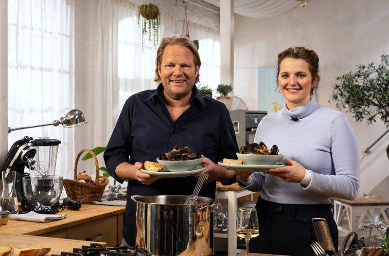 Gastgeber Björn Freitag mit Gastköchin Luisa Jordan aus dem schönen Rheinhessen. Sie nimmt Björn Freitag mit auf eine kulinarische Reise in ihre Kindheit: Miesmuscheln in fruchtiger Tomatensoße wecken bei ihr Erinnerungen an Urlaube am Meer. Dazu gibt’s knusprig-würziges Knoblauchbrot – so einfach wie köstlich! Weiteres Bildmaterial finden Sie unter www.br-foto.de. – Bild: WDR/​2Bild GmbH