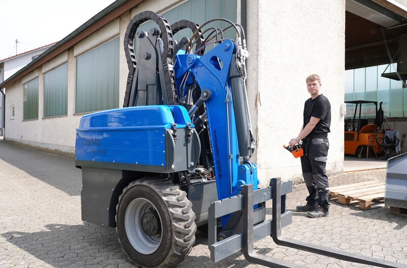 Erfinder Jonas Heinzler aus Ulm neben seiner Erfindung, dem sein fernsteuerbarer Radlader – Bild: MDR/​Felix Hugenschmidt