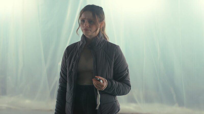 Bea (Aoife Hughes) und die anderen Übriggebliebenen haben herausgefunden, dass das Alien sich alle 16 Minuten neu laden muss. Nun wollen sie sich gegenseitig beobachten, ob eine von ihnen in diesen 16 Minuten flackert. – Bild: ZDF/​Zodiak Kids & Family Productions UK Ltd.