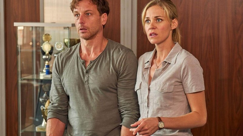 Stefan Vollmer (Hendrik Duryn) und Karin Noske (Jessica Ginkel) denken Direktor Rose würde wieder trinken und suchen in seinem Büro nach Alkohol. Der erwischt die Beiden und zeigt sich voller Energie für seinen Job. – Bild: TVNOW /​ Frank Dicks