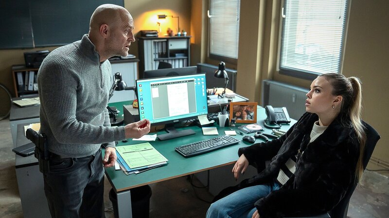 Im Präsidium steht der Hauptkommissar und Vater vor seiner Tochter und gestikuliert, sie schaut ratlos und fragend: Jürgen Vogel als Robert Heffler, Lea Zoë Voss als Carlotta Heffler – Bild: SRF/​ZDF/​Oliver Feist