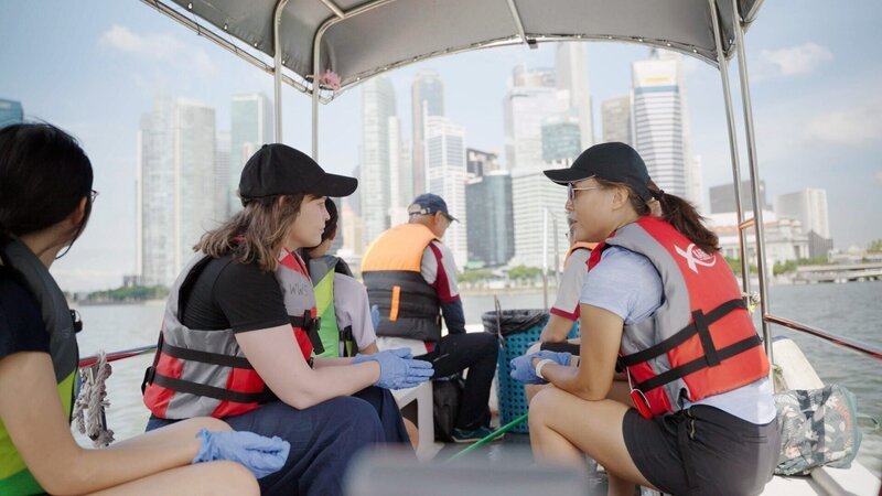 ORF-Korrespondentin Isabella Purkart mit Freiwilligen auf dem Marina Reservoir. – Bild: ORF