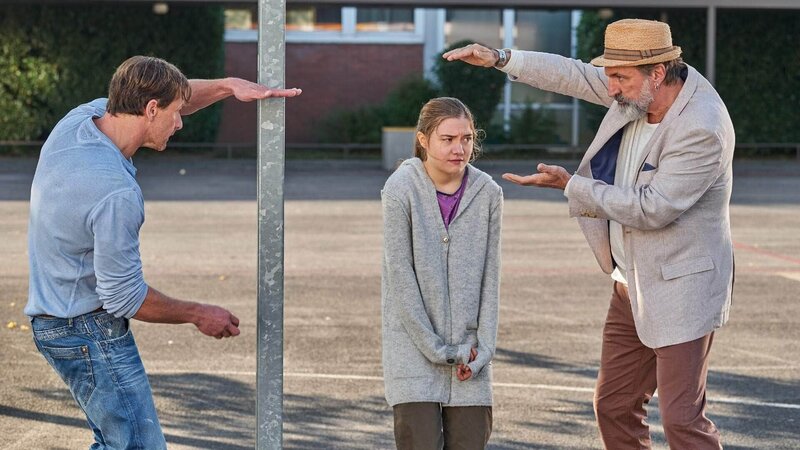 Karins Vater Walter (Andras Hoppe, r.) hilft Stefan (Hendrik Duryn), der extrem schüchternen Schülerin Judith (Hannah Schiller) mehr Selbstvertrauen und eine bessere Körperhaltung aufzubauen. – Bild: TVNOW /​ Frank Dicks