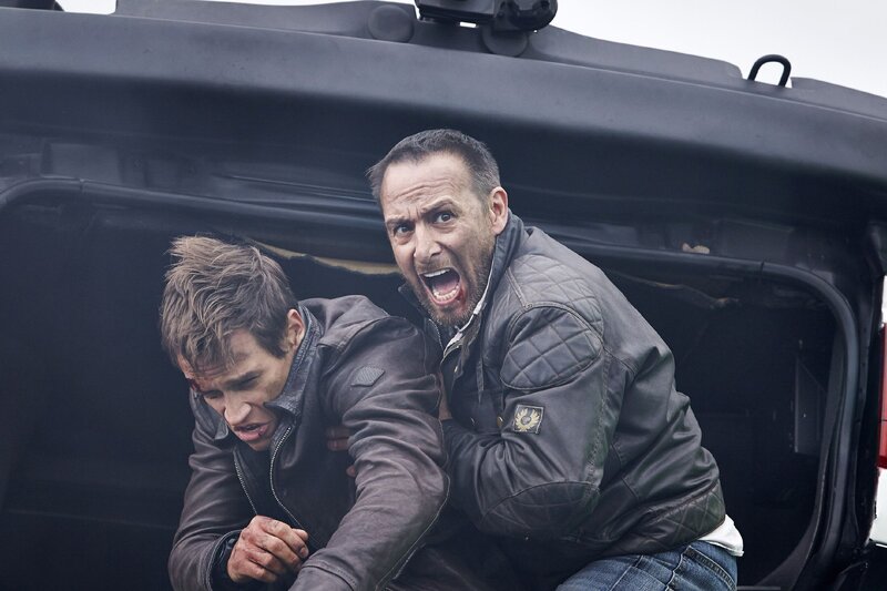 Im allerletzten Moment schafft es Semir (Erdogan Atalay, r.) den bewusstlosen Alex (Vinzenz Kiefer) aus dem völlig zerstörten Jeep zu retten, bevor dieser mit dem LKW explodiert. – Bild: MG RTL D /​ Guido Engels