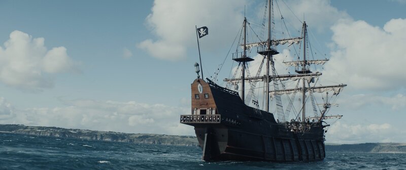 REENACTMENT – Ein Piratenschiff segelt mit der Jolly Roger Flagge auf dem Meer. (Kredit: Dash Pictures) – Bild: Dash Pictures /​ Dash Pictures