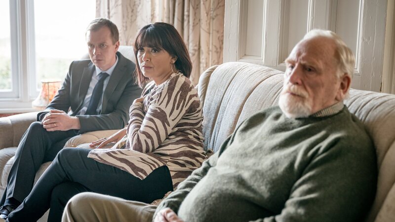Mark Bradwell (Steven Robertson, l.) und Stella Bradwell (Sunetra Sarker, M.) möchten unbedingt wissen, ob der Todesfall des Kommissars mit dem Mord ihres Schwagers zusammenhängt. Bill Bradwell (James Cosmo, r.) zeigt dagegen mehr Verständnis gegenüber Lisa Armstrong. – Bild: ZDF und Ben Blackall