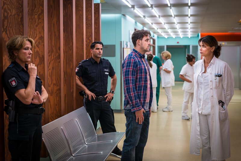 Jasmin (Gerit Kling, r.) muss Julius Reinke (Marc Barthel, M.) mitteilen, dass seine hochschwangere Frau ihren Verletzungen erlegen ist. Es besteht aber die Chance, das Baby noch gesund zur Welt zu bringen. Claudia (Janette Rauch, l.) und Tarik (Serhat Cokgezen, 2.v.l.) nimmt die Nachricht ebenso mit. – Bild: ZDF/​Boris Laewen