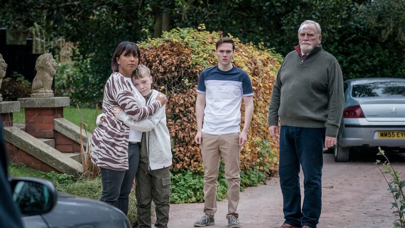 Stella Bradwell (Sunetra Sarker, l.) tröstet Oliver Marshbrook (Leo Ashton, 2.v.l.), während sich Jamie Marshbrook (Jack Archer, 2.v.r.) und Bill Bradwell (James Cosmo, r.) darüber beschweren, dass Rose von den Kommissaren mitgenommen wird. Sie möchten ihr ein paar Fragen stellen. – Bild: ZDF und Ben Blackall