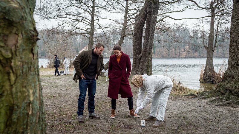 Kriminaltechnikerin Roswitha Prinzler (Silke Matthias, r.) zeigt Karoline Joost (Nike Fuhrmann, M.) und Lars Pöhlmann (Dominic Boeer, l.) Spuren von Patronenhülsen am Tatort. Der Täter hat zwei Mal auf den Toten geschossen. Für die Kommissare ist klar, was das bedeutet: Der Täter hat Daniel Kahlke unbedingt töten wollen. Doch warum musste der Hundezüchter sterben? – Bild: Marc Meyerbröker /​ ZDF