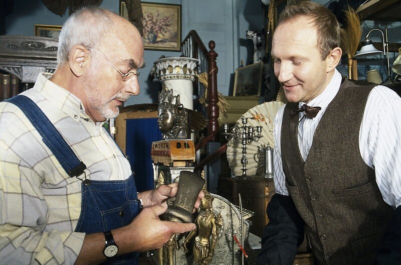 Peter (Peter Lustig, l.) will im Antiquitätenladen bei Herrn Windig (Alexander Hauff, r.) ein Geburtstagsgeschenk für Tante Elli kaufen – edel soll es sein und aus Metall. – Bild: ZDF