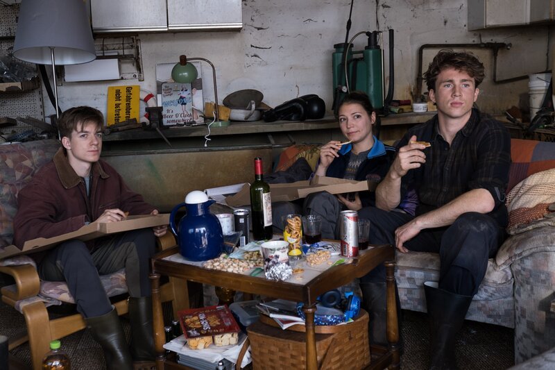 Das junge Gärtnerteam, Maria Inonesco (Irina Potapenko, M.), Lasse Möller (Justus Johanssen, r.) und sein Bruder Rico (Nick Julius Schuck, l.) geht ziemlich entspannt mit den Fragen der Sylter Kommissare zum Mord an ihrem Auftraggeber Friedel Tanner um. – Bild: Manju Sawhney /​ ZDF