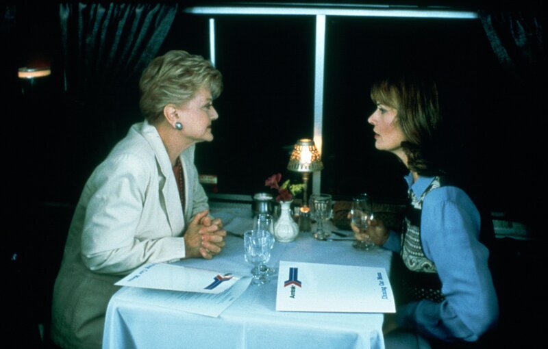 Im Zug lernt Jessica Fletcher (Angela Lansbury, l.) die unter Personenschutz stehende Sarah McLeish (Mel Harris, r.) kennen. Als sich Sarah während des Lunchs kurz entschuldigt, dann aber nicht wieder kommt, ist die berühmte Krimiautorin höchst alarmiert. – Bild: Universal Pictures Im Zug lernt Jessica Fletcher (Angela Lansbury, l.) die unter Personenschutz stehende Sarah McLeish (Mel Harris, r.) kennen. Als sich Sarah während des Lunchs kurz entschuldigt, dann aber nicht wieder kommt, ist die berühmte Krimiautorin höchst alarmiert. – Bild: Universal Pictures