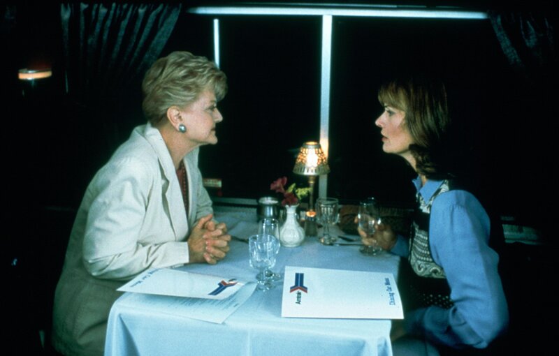 Im Zug lernt Jessica Fletcher (Angela Lansbury, l.) die unter Personenschutz stehende Sarah McLeish (Mel Harris, r.) kennen. Als sich Sarah während des Lunchs kurz entschuldigt, dann aber nicht wieder kommt, ist die berühmte Krimiautorin höchst alarmiert. – Bild: Universal Pictures