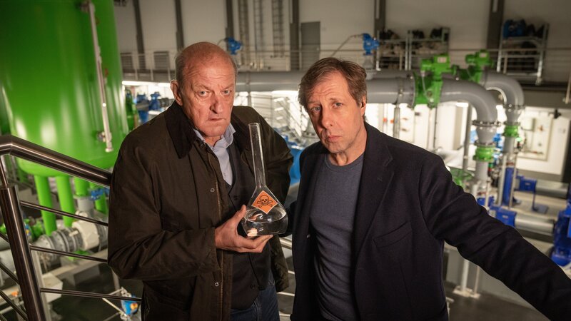 Aus Wilsbergs (Leonard Lansink, l.) Wasserhahn kommt kein Tropfen mehr. Er hat seine Rechnung nicht gezahlt, denn die Wasserpreise steigen enorm an, seitdem eine private Betreiberfirma die örtliche Wasserversorgung übernommen hat. Als ein Whistleblower tot aufgefunden wird und ein Aktivist verschwindet, müssen Wilsberg und Ekki (Oliver Korittke, r.) die Fährten aufnehmen. – Bild: Thomas Kost /​ ZDF