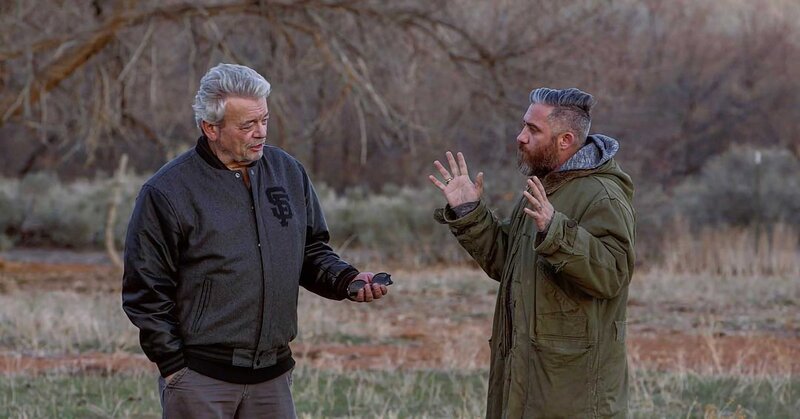 Zwei Männer stehen im Freien und unterhalten sich, wobei einer von ihnen lebhaft gestikuliert. – Bild: box link /​ THE HISTORY CHANNEL /​ A+E Networks /​ FOUR NAME PRODUCTIONS, LLC