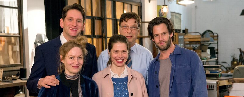 Carla Temme (Meike Droste, M.), ihr pedantischer Chef Hans-Peter Mühlens (Martin Brambach), ihr nassforscher Konkurrent Frank Weber (Sebastian Schwarz), ihre Schwester Hannah (Anna Blomeier) und Mikael (Richard Ulfsäter). – Bild: ARD/​Jens van Zoest