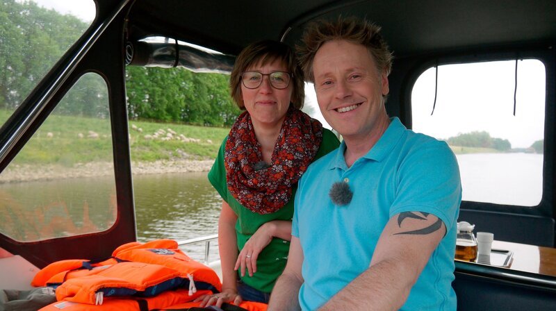 Drei Wasserstraßen, zwei Reisende, ein Hausboot: Stefan Pinnow (r) und seine Kapitänin Christine Drühl schippern zunächst auf der Havel von Berlin über Werder nach Brandenburg. – Bild: WDR/​Per Schnell