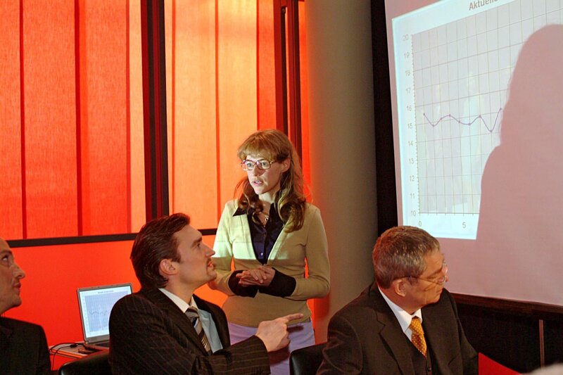 Völlig überrumpelt muss Lisa (Alexandra Neldel, M.) in der Vorstandssitzung vor Friedrich Seidel (Wilhelm Manske, r.) und Richard von Brahmberg (Karim Köster, l.) Davids Präsentation halten. Zunächst läuft auch alles schief … – Bild: SAT.1 /​ Noreen Flynn