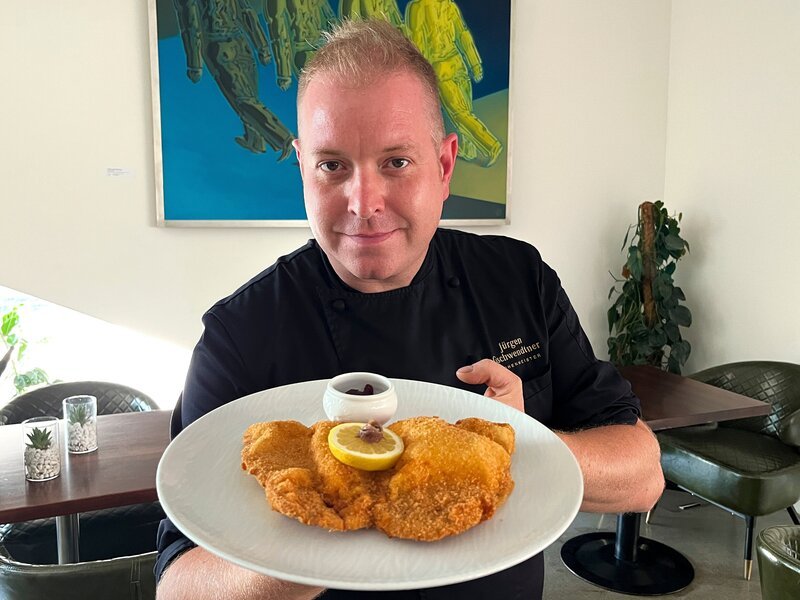 Nahaufnahme Koch mit fertigem Wiener Schnitzel während Servus TVs „TM Wissen“ – Bild: ServusTV /​ Hanna Jungwirth /​ Terra Mater Studios