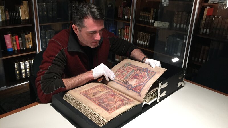 Rob untersucht einen alten irischen Text im Book of Kells. – Bild: Discovery Communications/​Meryl Groff