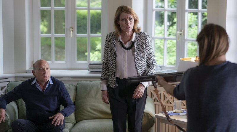 Renate Willenberg (Kirsten Block, M.) ist schockiert, als Klara (Klara Manzel, r.) das Gewehr auf ihren Vater André (Ulrich Gebauer, l.) richtet. – Bild: Degeto Film GmbH | OneGate Media GmbH