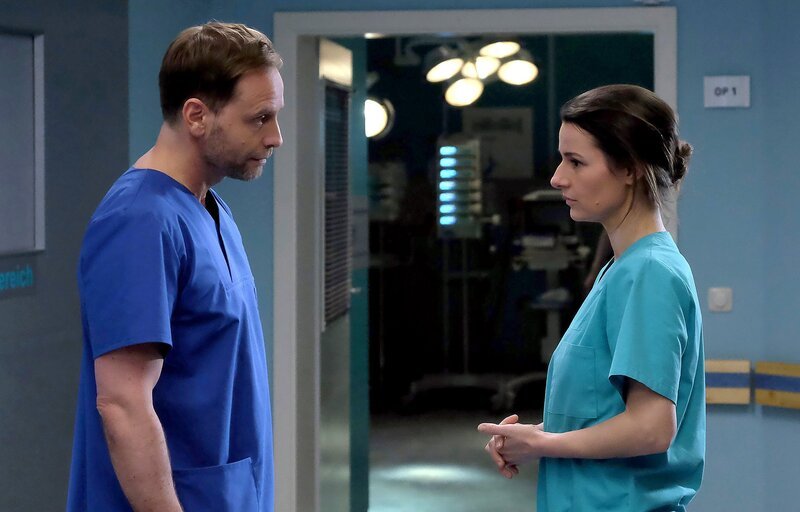 Dr. Maria Weber (Annett Renneberg) entschuldigt sich bei Chefarzt Dr. Kai Hoffmann (Julian Weigend) für ihren Zusammenbruch im OP. Doch Hoffmann hat vollstes Verständnis für Marias Erschöpfung und spricht ihr ein Kompliment aus: Durch Marias Beharrlichkeit hat sie dem Patienten das Leben gerettet. – Bild: MDR/​Saxonia Media/​Kiss