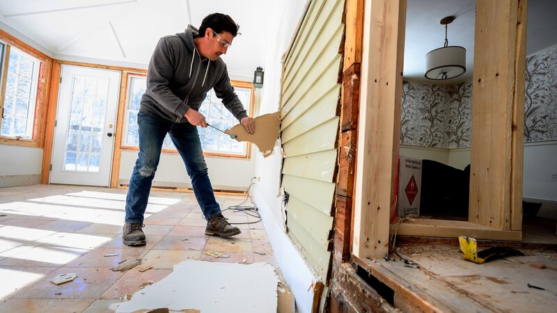 Jonathan Knight works to remove drywall in the sunroom during demolition at the Ipswich farmhouse project, as seen on Farmhouse Fixer. (interior) (before) – Bild: Discovery, Inc. /​ Shawn G. Henry/​Getty Images