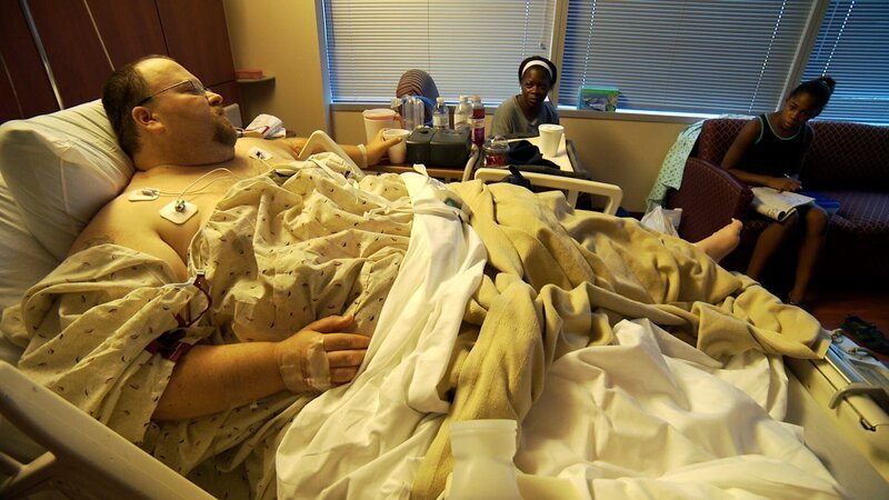 Chad im Krankenhausbett nach der Operation mit seiner Frau Ayesha und Tochter Taque. – Bild: Discovery Communications